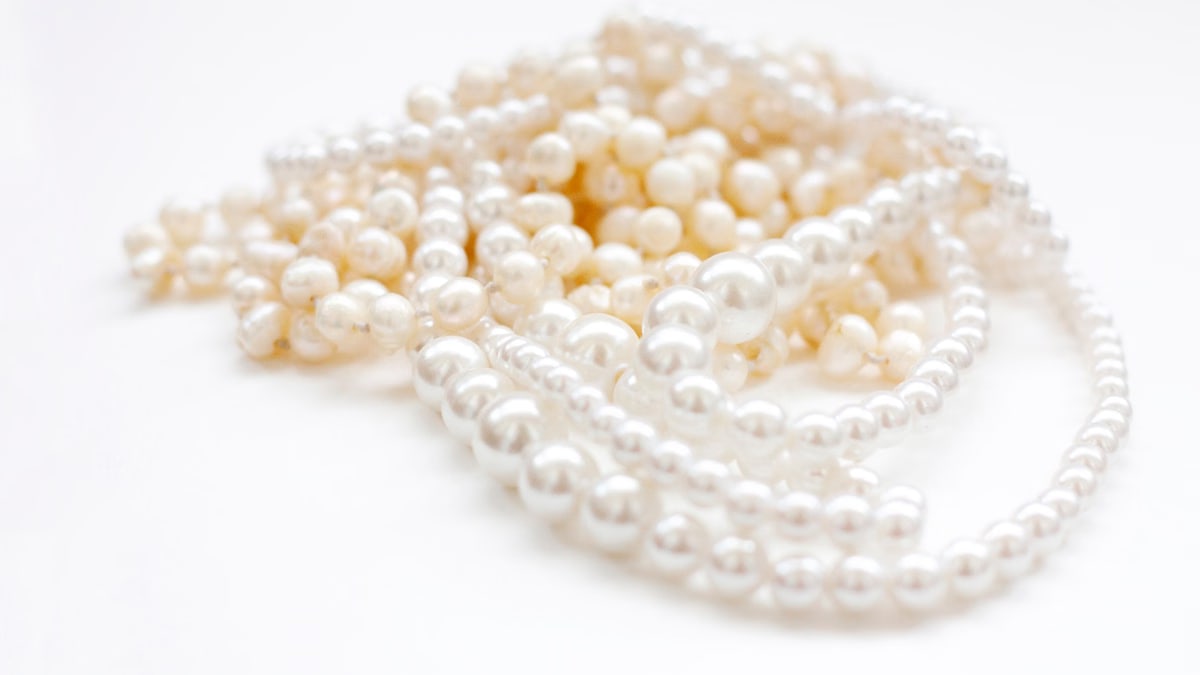 Close-up of elegant white pearl necklaces displaying classic beauty on a soft background.